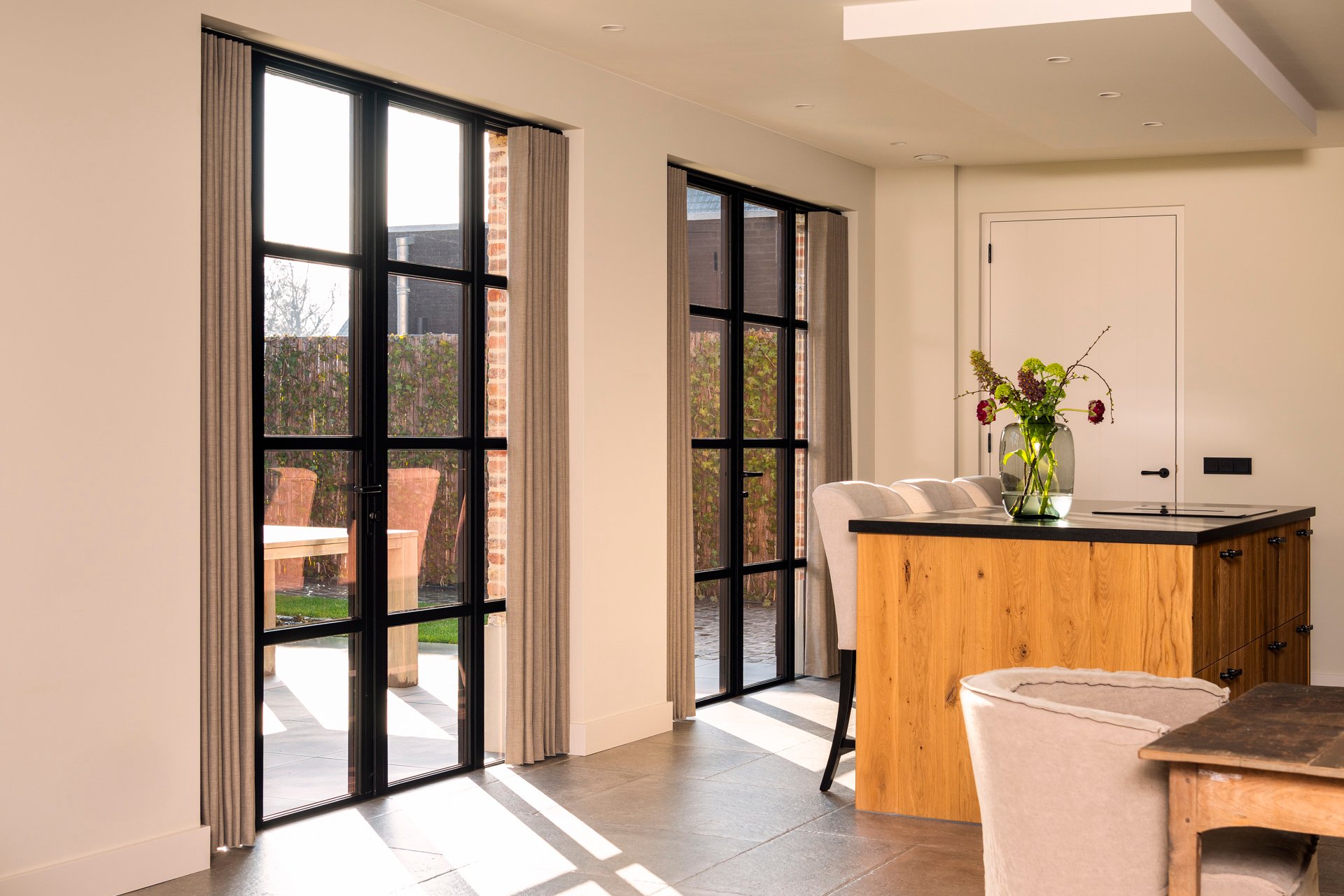 Stalen buitendeur Toronto met zijlichten vanuit woonkeuken richting bijkeuken, beide deuren gesloten, doorkijk naar tuin, kempische nieuwbouwwoning Kesteren